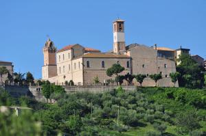 a large building with two towers on top of a hill at La Rue in Tortoreto Lido