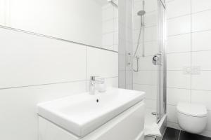 a white bathroom with a sink and a toilet at Löwe Apartment Gelb Tiengen Altstadt in Waldshut-Tiengen