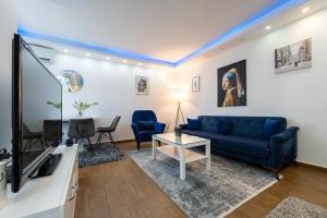 a living room with a blue couch and a tv at BlueMont Apartment in Podgorica