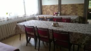 a dining room with a table with red chairs and a tableablish at Trzecie Jezioro in Szypliszki