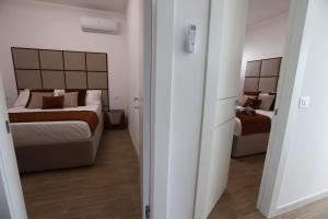 a hotel room with two beds and a couch in it at Residence Costa dei gigli 2 in Simeri Mare