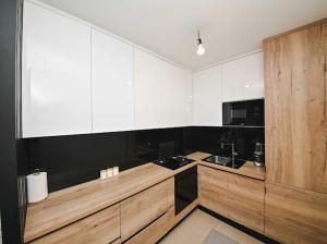 a kitchen with white cabinets and wooden counters at Bjelašnica Ski View Apartment in Bjelašnica
