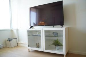 リッチモンドにあるCozy Richmond Center Downtown 2B & 2B Apartmentの白いエンターテイメントセンターの上のテレビ