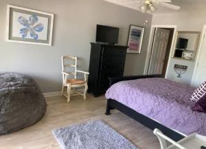 a bedroom with a purple bed and a chair at 25 Sweet Serenity in Centre