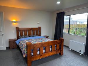 タウランガにあるTauranga Harbour Viewのベッドルーム1室(木製ベッド1台、窓付)