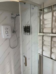 a bathroom with a shower with towels in it at The Stags Den - North Coast Luxury Pods in Skaill