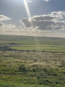 a view of a field with a rainbow in the sky at The Stags Den - North Coast Luxury Pods in Skaill