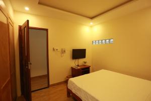 a bedroom with a bed and a television at Gia Loi Hotel in Danang
