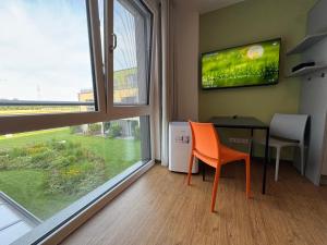 a room with a table and a chair and a television at Fair n Square Hotel 24 Stunden Self-Check In in Darmstadt