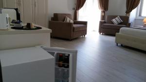uma sala de estar com um frigorífico e garrafas de vinho em Brilliant Camere em Trieste