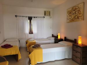 圣米格尔-杜戈斯托苏Espaço Varanda e Mar的客房设有3张带黄色床单的床和窗户。 更多46张照片