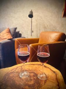 two glasses of wine sitting on a wooden table at Boutique Flat com Banheira Lareira e Piscina Aquecida in Campos do Jordão +108 photos