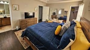 a bedroom with a large blue bed and a bathroom at Lg Deck-BBQ Grill - King Suite - Near RAFB in Bonaire