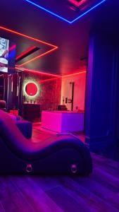 een woonkamer met paarse verlichting en een bank bij Love room - Xtase By luxuria Cannes in Cannes