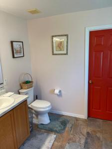 a bathroom with a toilet and a red door at Magic Stay 4-Bedroom Home Close to Disney in Kissimmee