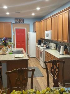 a kitchen with wooden cabinets and a white refrigerator at Magic Stay 4-Bedroom Home Close to Disney in Kissimmee
