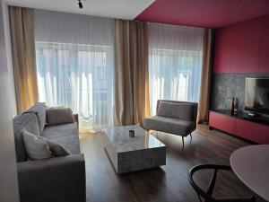 a living room with a couch and a chair at Apartament Dzierżonia 12 in Katowice +9 photos