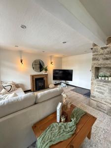 a living room with a couch and a fireplace at Yorkshire Barn Escape 2 bedroom in Keighley