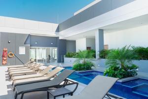 a pool with lounge chairs and a swimming pool at Ámbar Roca / Rodadero in Rodadero