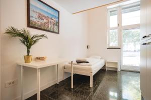 a room with a white desk and a plant at LightBox Central in Ljubljana