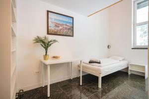 a white room with a white desk and a plant at LightBox Central in Ljubljana