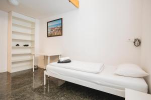 a white room with a bed and a desk at LightBox Central in Ljubljana