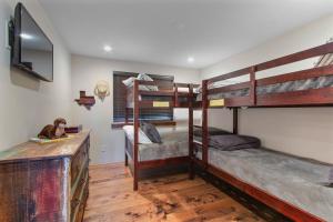 1 dormitorio con 3 literas y escritorio en Cabin Masterpiece on Private Lake 3 bedroom, en Pittsburg