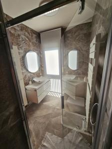 a bathroom with two sinks and two mirrors at Blu Petrolio Stay-Karabas Apartments in Vicenza