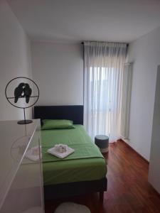 a bedroom with a green bed and a glass table at Blu Petrolio Stay-Karabas Apartments in Vicenza