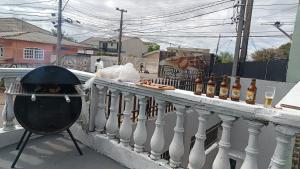 a grill on a balcony with a bunch of bottles at Sobrado in Curitiba