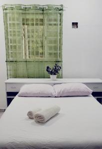 a white bed with two towels on top of it at Dream House in Ananindeua