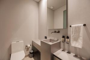a white bathroom with a sink and a mirror at Sereno Building in Medellín +15 photos