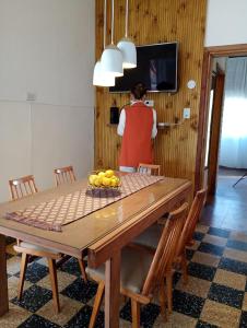 une femme dans une cuisine avec une table avec un bol de fruits dans l'établissement Vivienda de alquiler por dia completa en Junin, à Junín