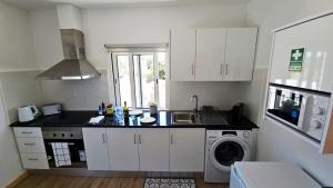a kitchen with a sink and a washing machine at Top Floor in Flor do Campo - Santana in Santana