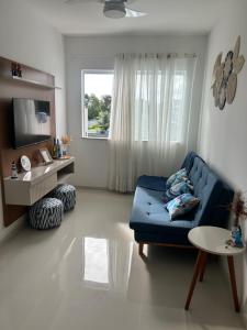 a living room with a blue couch and a window at Village em Barra do Jacuípe in Camaçari