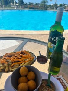 a table with a plate of food and a bottle of soda at Village em Barra do Jacuípe in Camaçari