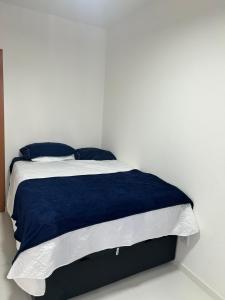 a bed with blue and white sheets and pillows at Village em Barra do Jacuípe in Camaçari +32 photos