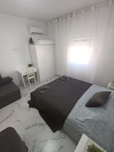 a bedroom with a large bed in a white room at Nuevo apartamento cerca del mar in Denia
