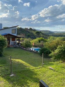 ein Haus mit Zaun und ein Garten mit Pool in der Unterkunft Brisas Serranas in Villa Icho Cruz