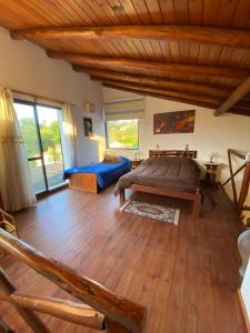 ein Schlafzimmer mit großem Bett und Holzboden in der Unterkunft Brisas Serranas in Villa Icho Cruz