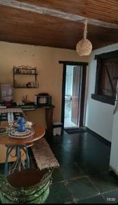 Una sala de estar con una mesa y un comedor. en Chalé Beira Rio Cipó, en Serra do Cipo