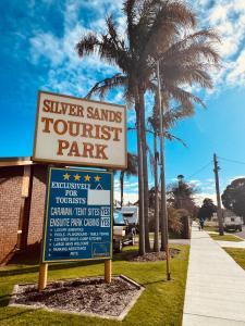 a sign for a volleyball park with a palm tree at Silver Sands Tourist Park in Lakes Entrance