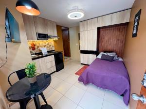 a bedroom with a bed and a table and a kitchen at 05 Habitación tranquila a pasos de Ceconexpo in Morelia