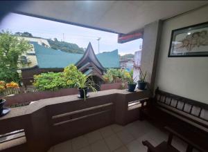 a balcony with potted plants and a large window at Gotico Central Residence-Level 2 in Dapa