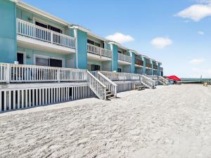 a row of buildings on the beach next to the sand at Bayfront Kontiki 107 in Rockport