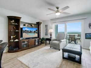 a living room with a tv and a couch and a chair at Bayfront Kontiki 107 in Rockport