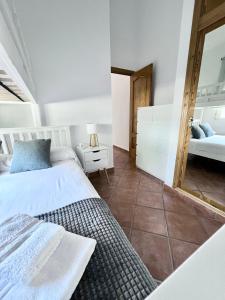 ein Schlafzimmer mit zwei Betten und einem Spiegel in der Unterkunft Relaxdiversión en Villa Piscina bbq y cocina ext in Calpe