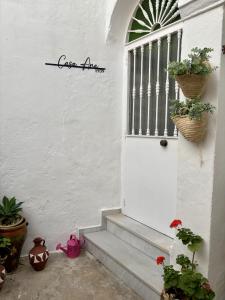 a white door with two potted plants on it at Casa Ana in Vejer de la Frontera