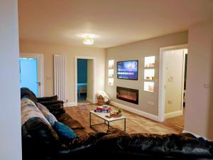 a living room with a couch and a tv at Kelly's Country Cottage in Rookwood
