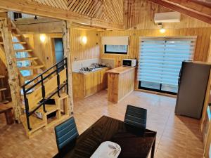a kitchen with a staircase in a wooden cabin at Cabañas Del Monte 1 in Melipeuco